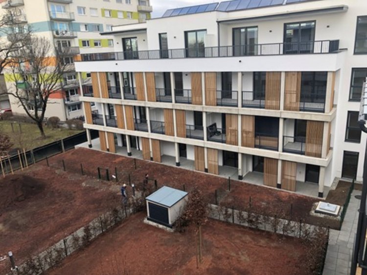 Moderner Neubau mit Balkonen und kleinen Gärten.