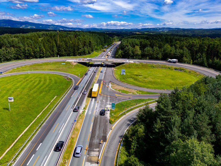 Aerial view of a motorway junction surrounded by green space and trees