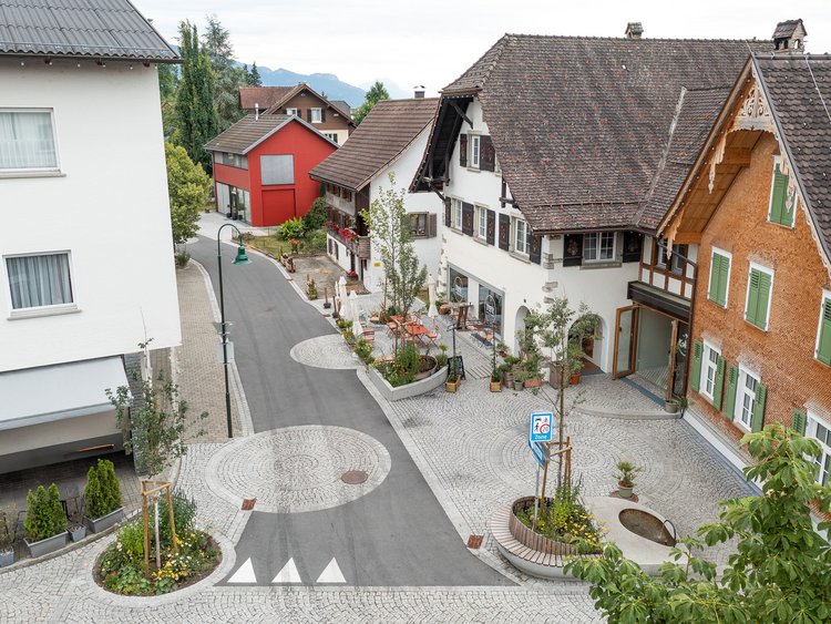 A bird’s-eye view of the village street with traditional apartment blocks